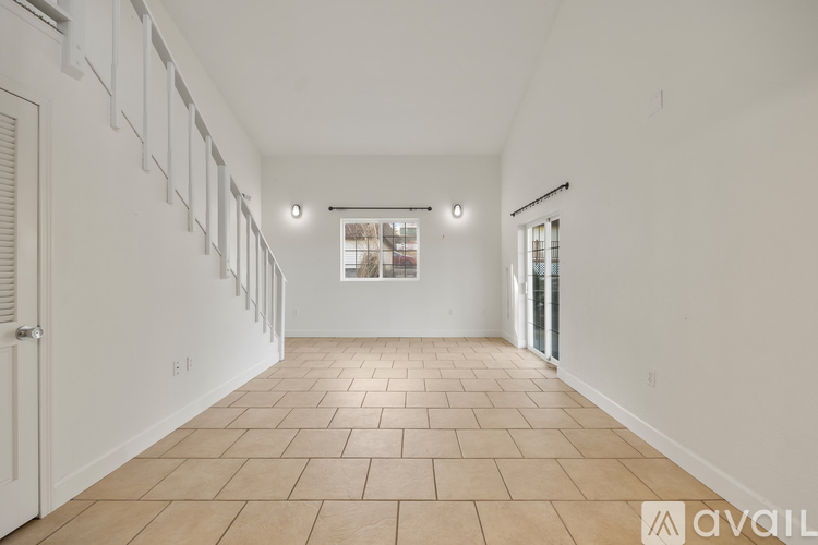 A spacious room with tiled flooring and white walls.