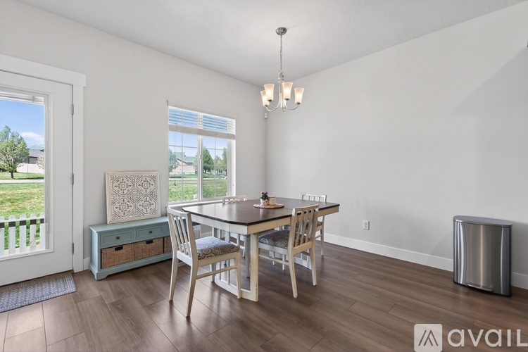 A dining room with a table and chairs.