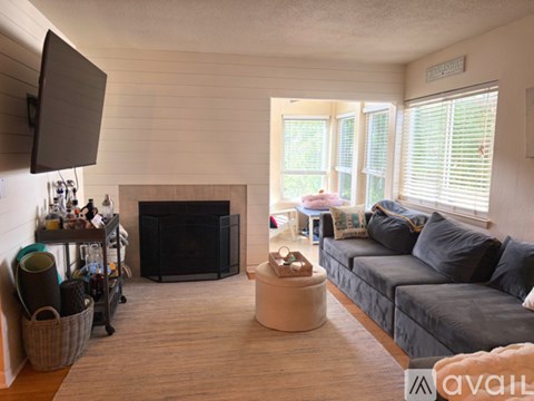 A living room with a grey couch and a fireplace.