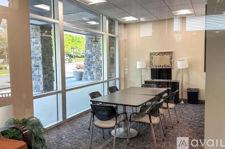 A conference room with a table, chairs, and a television.