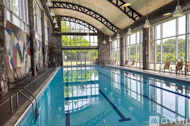 A large indoor swimming pool with a glass wall on one side.