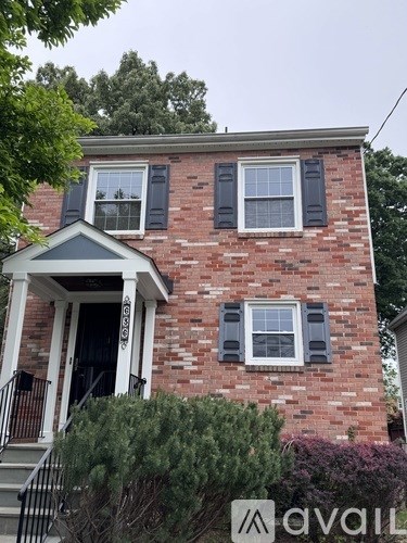 A brick house with a porch and a window with shutters.