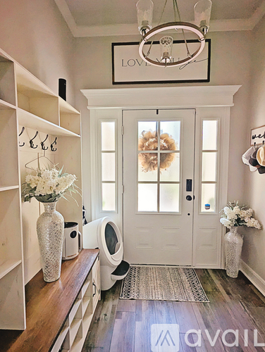 A hallway with a wooden floor and a white door.