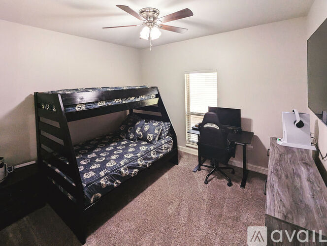 A bedroom with a bunk bed and a desk.