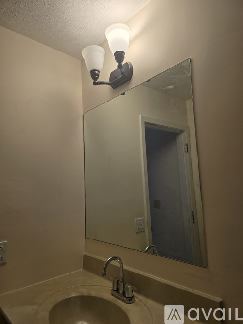 A bathroom sink under a mirror with a light above it.