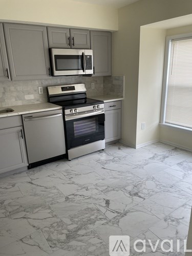 A kitchen with a marble floor and a window.