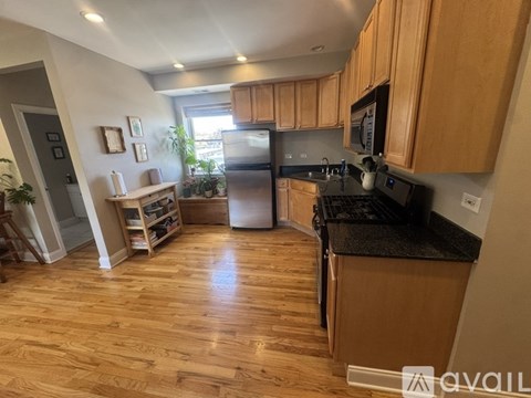 A kitchen with wooden cabinets and a black countertop.