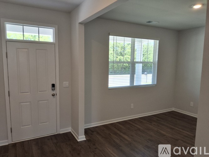 A room with a white door and a window with blinds.