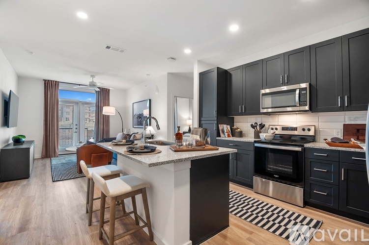 A modern kitchen with black cabinets and a central island.