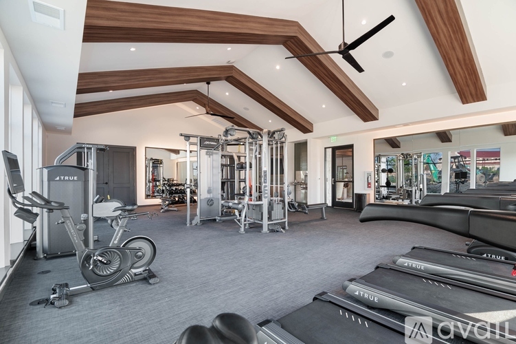 A gym with a variety of equipment including treadmills, exercise bikes, and weight machines.