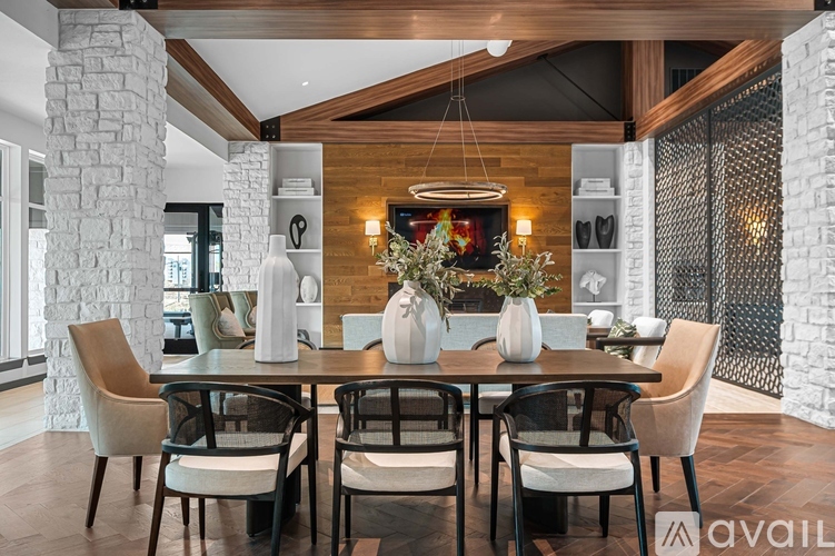 A modern dining room with a stone pillar and a wooden table.