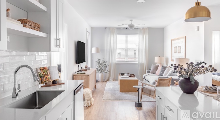 A modern kitchen with a large island and a living area with a couch and a coffee table.