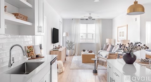 A modern kitchen with a large island and a living area with a couch and a coffee table.
