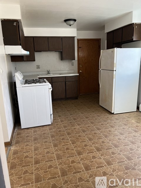A kitchen with a white fridge and a white washing machine.