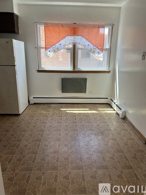 A room with a window and a tiled floor.