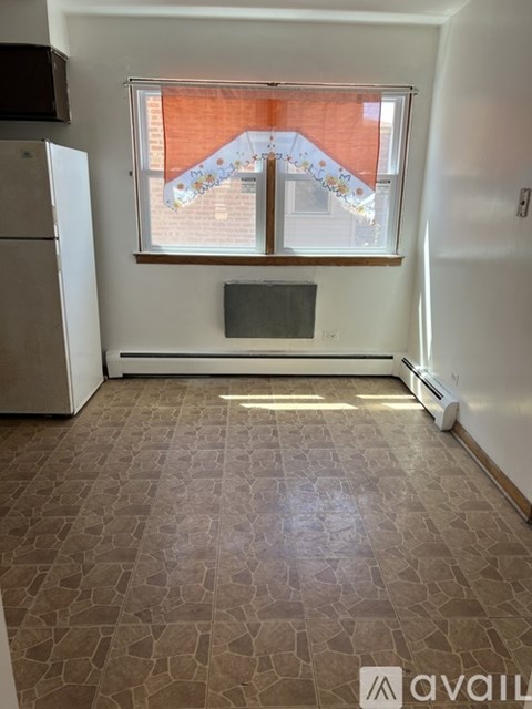 A room with a window and a tiled floor.
