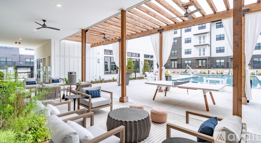 A modern outdoor seating area with a pool in the background.