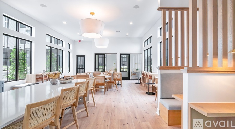 A modern dining room with wooden chairs and a long table.