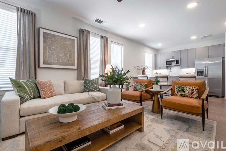A living room with a couch, chairs, and a coffee table.
