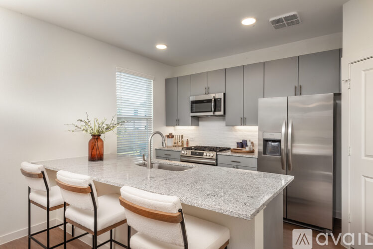 A kitchen with a granite countertop and stainless steel appliances.