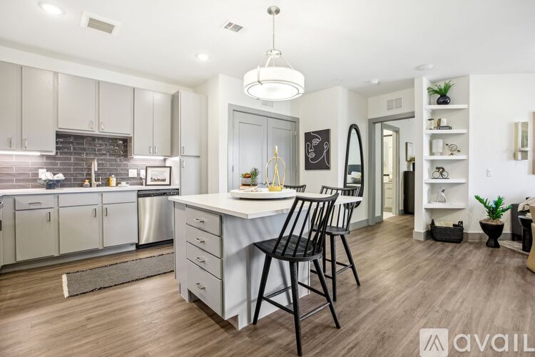 A modern kitchen with a dining area and a living area.