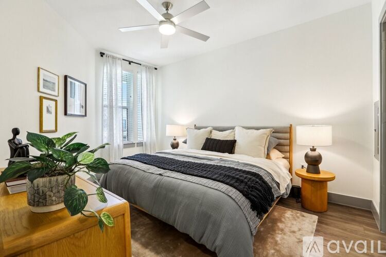 A well-lit bedroom with a large bed and a ceiling fan.
