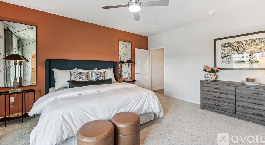 A bedroom with a large bed, a dresser, and a ceiling fan.