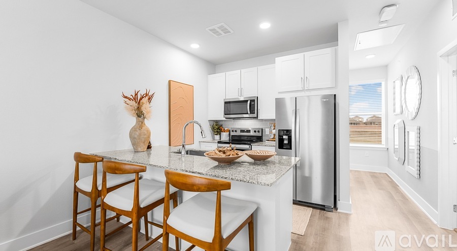 A kitchen with a table and chairs in front of a refrigerator and microwave.