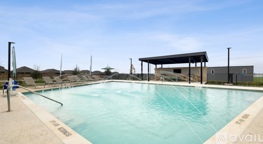 A large outdoor swimming pool with a covered area and lounge chairs.