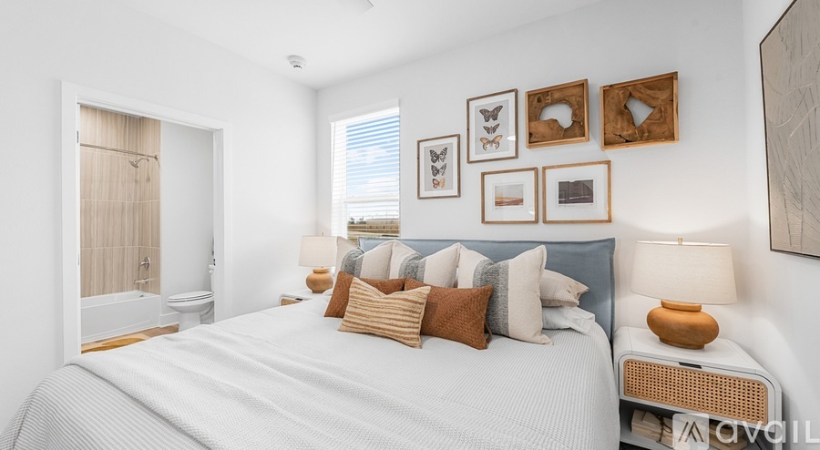 A bedroom with a large bed and a window with blinds.