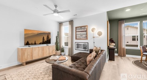 A living room with a brown leather couch and a wooden entertainment center.