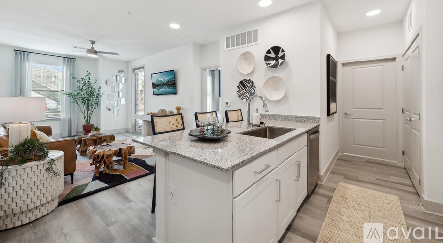 A modern kitchen with white cabinets and a marble countertop.