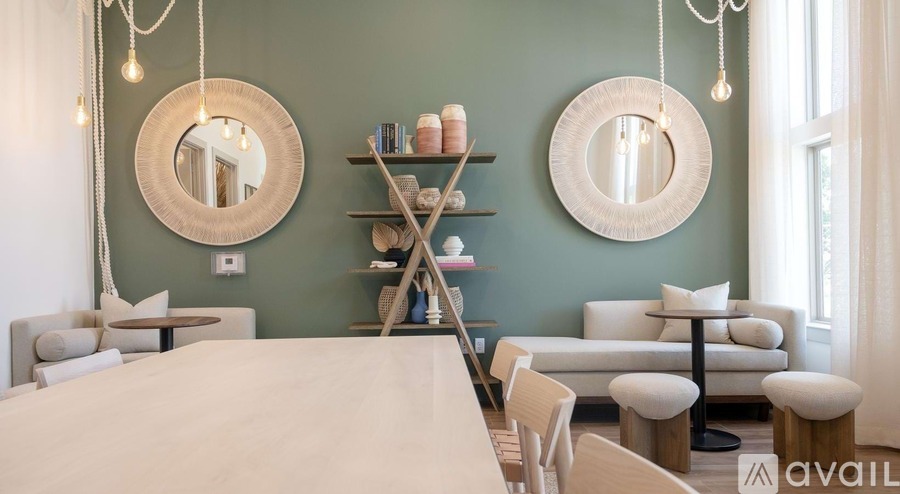 A bedroom with a bed, a chair, a table, and a mirror on the wall.
