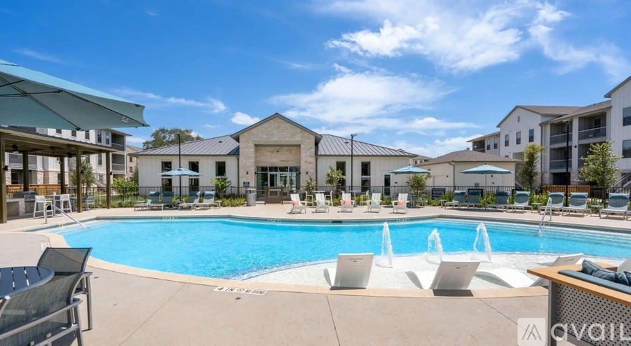 A pool area with a fountain and lounge chairs is available for use.