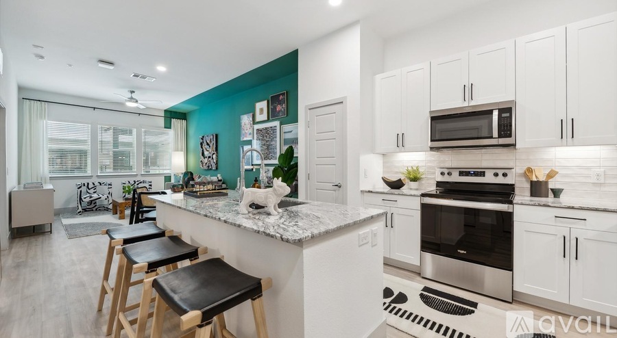 A kitchen with white cabinets and a blue accent wall.
