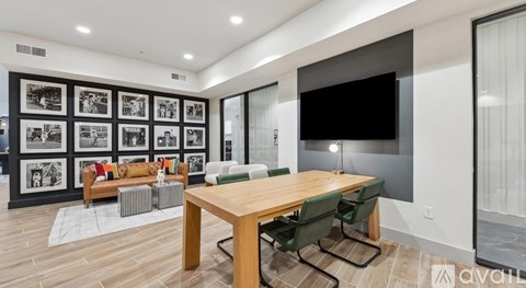 A modern living room with a wooden table and green chairs.