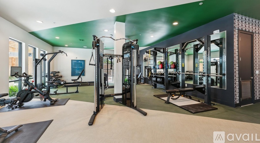 A gym with a variety of equipment including treadmills, weights, and exercise machines.