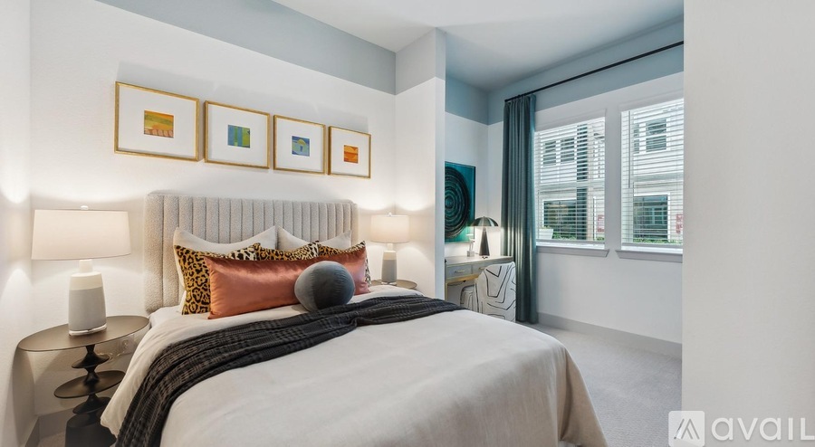 A bedroom with a large bed and a window with blinds.
