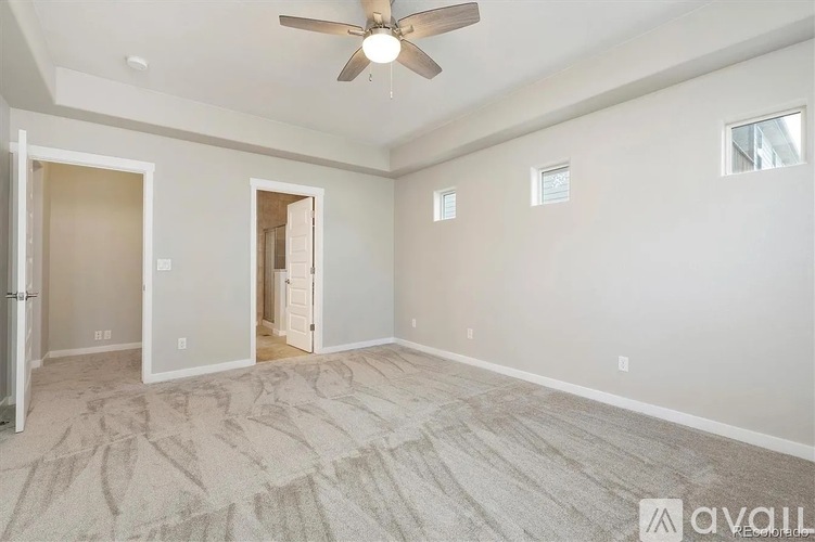 A room with a ceiling fan and a carpeted floor.