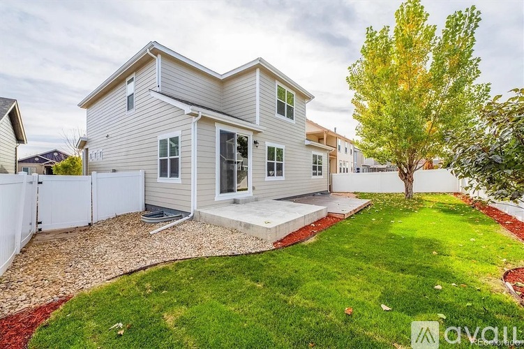 A house with a grey exterior and a white fence is for sale.