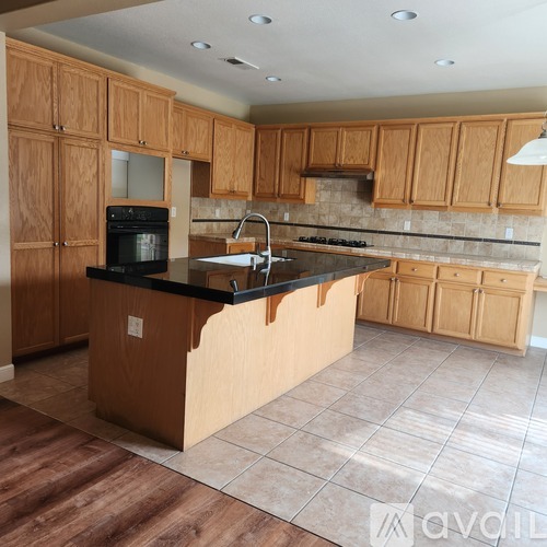 A kitchen with wooden cabinets and a black countertop.