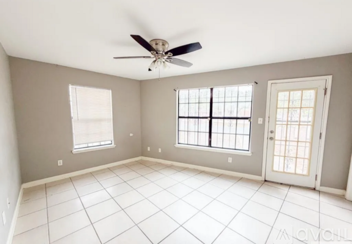 A room with a ceiling fan and tile flooring.