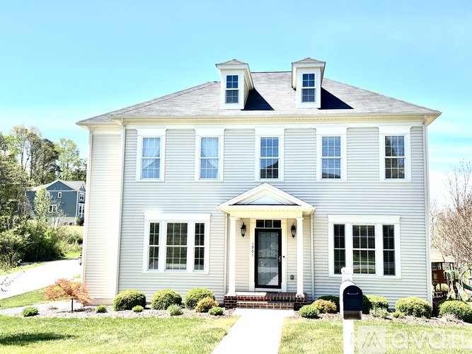 A two-story house with a front porch and a mailbox.