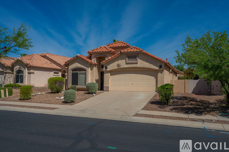 A house with a red tile roof and a garage door is for sale.