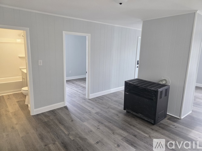 A room with a white door and green walls with white spots on them.