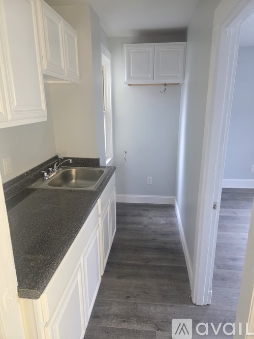 A kitchen with white cabinets and a granite countertop.