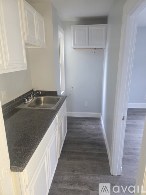 A kitchen with white cabinets and a granite countertop.