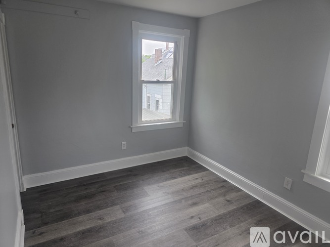 A room with a window showing a view of a building outside.
