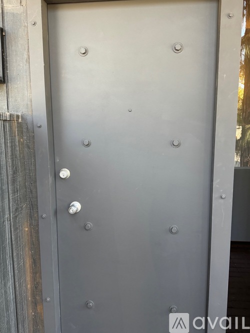 A metal door with rivets and a handle.