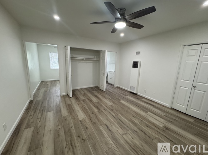 A room with a ceiling fan and wooden flooring.